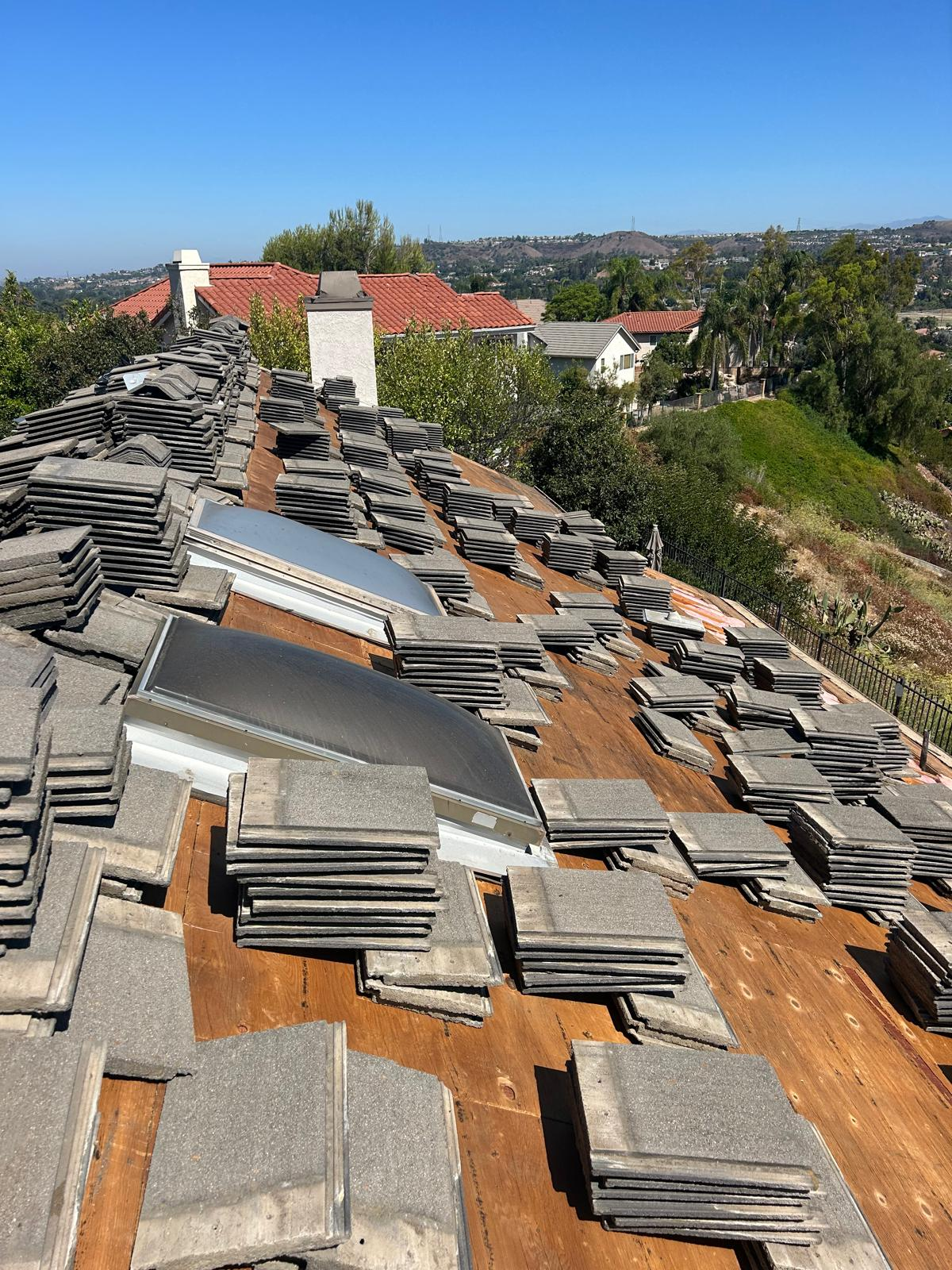 Gray concrete tiles stacked on wood deck with skylights